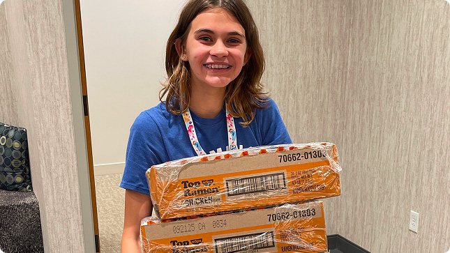 Girl with boxes of Ramen Noodles