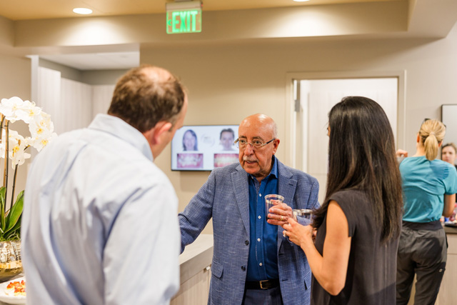 Dr. Farhad Moshiri speaking with others at his office