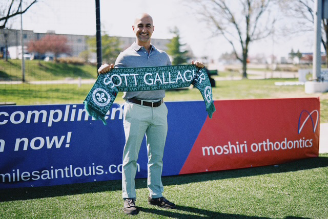 Dr. Maz holding a soccer scarf